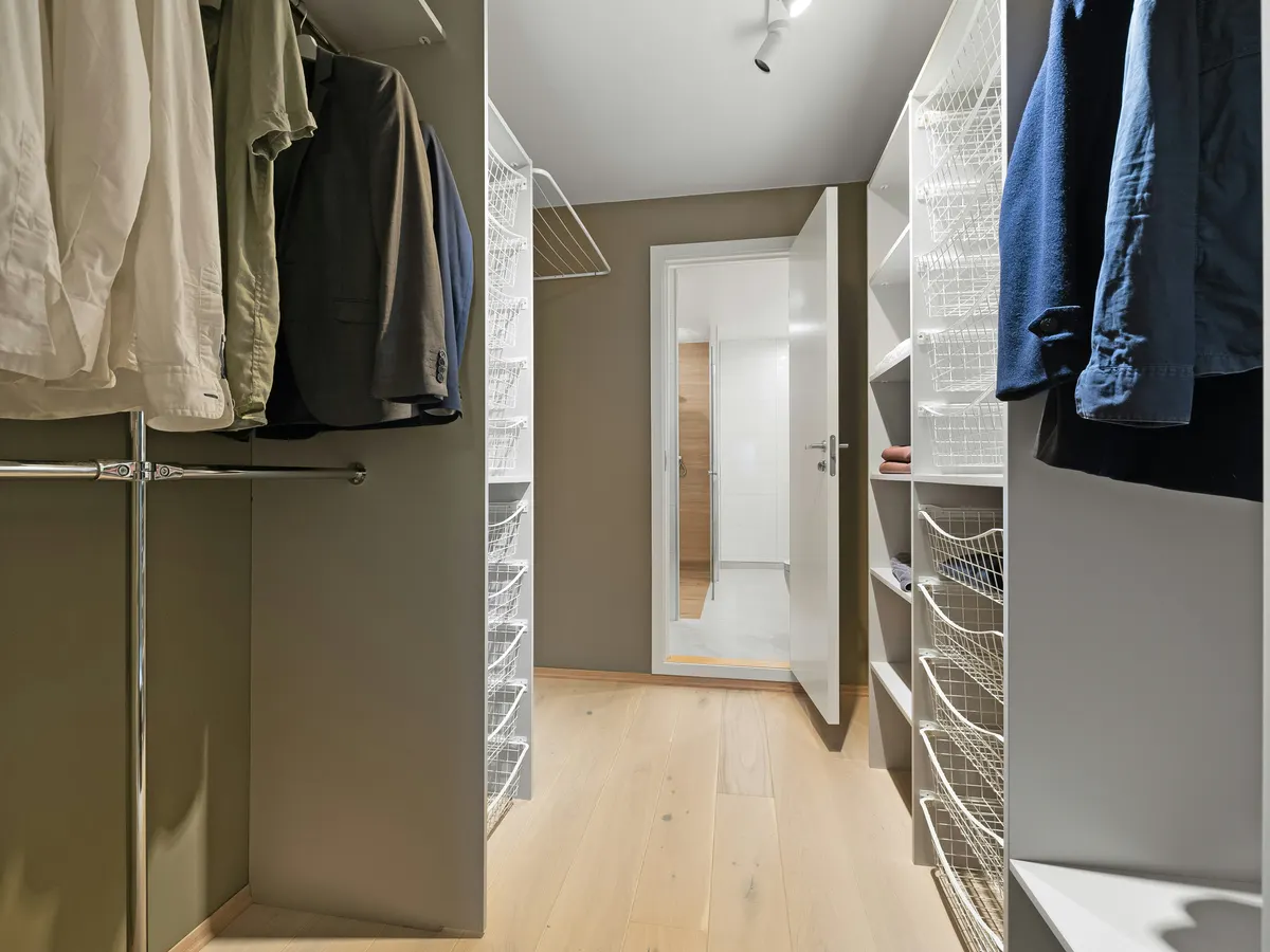 Walk-in closet well lit with dressing room