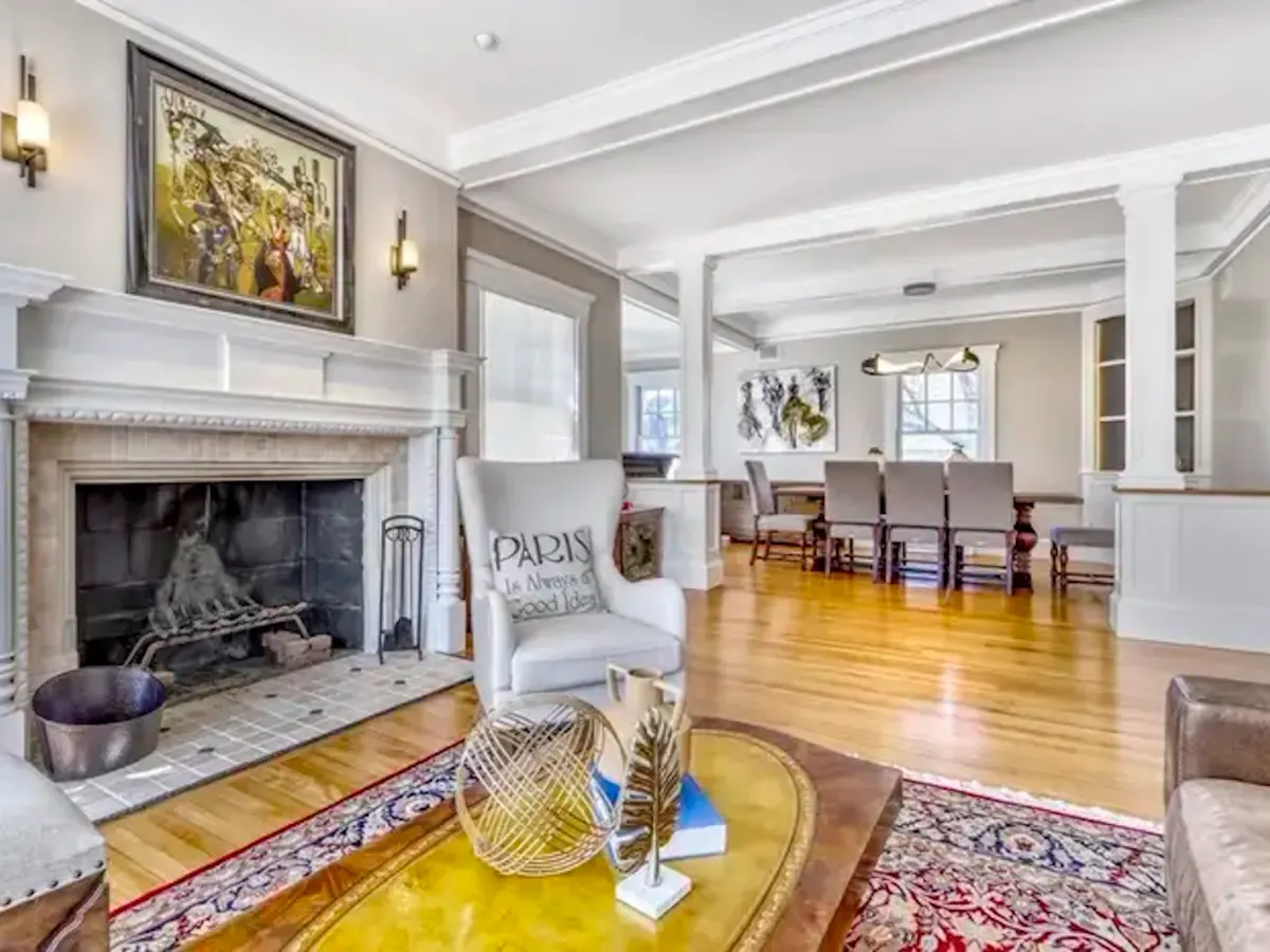 Setting with a Windwor Back easy chair in front of a classic fireplace and a couch with a view into the dining room.